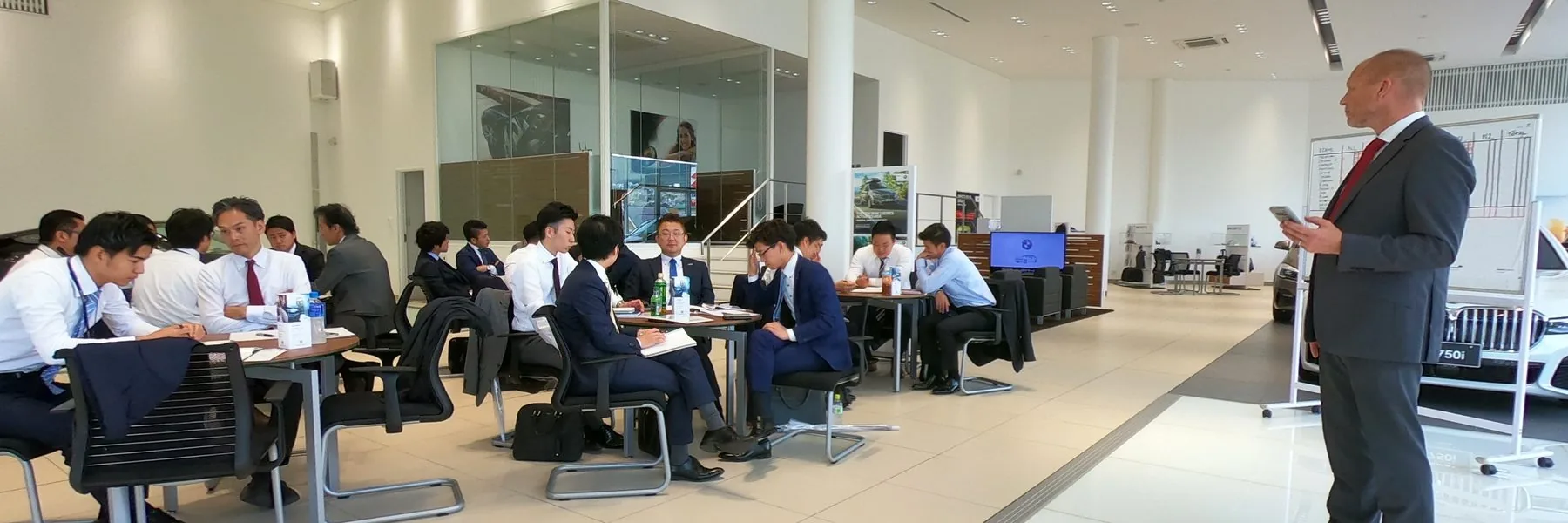 Jason running a session with a dealer team on a showroom floor in Japan