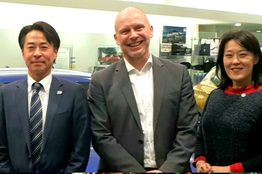 Jason with senior managers on a dealership floor in Japan